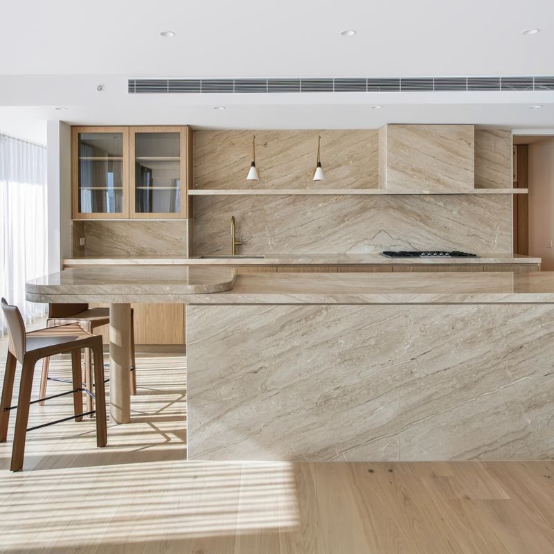 Kitchen with marble island and brass tapware in a South Yarra home plumbed by Scotland Marshall Plumbing